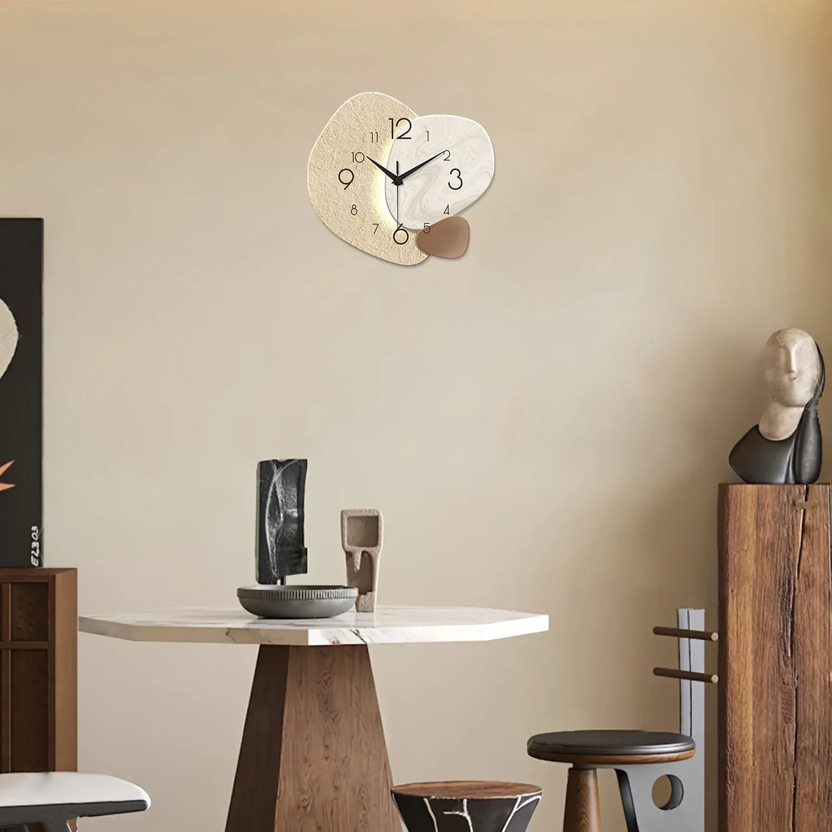 Skien wall clock high on a cream wall above a small round dining table and stools