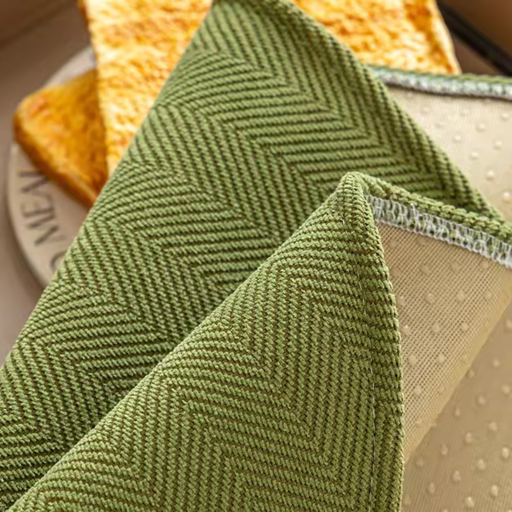 Close view of the fine woven face and dotted backing at the edge of the olive seat cover