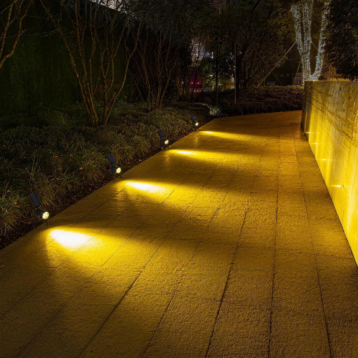 A row of solar spotlights lighting a garden path at night