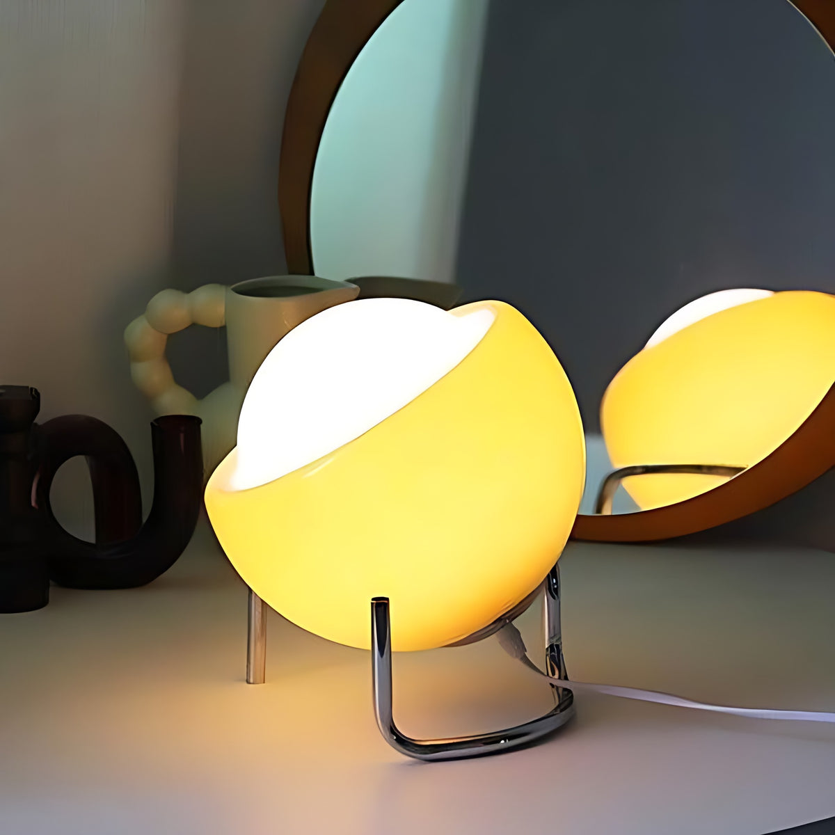 Solveig table lamp switched on beside a round mirror