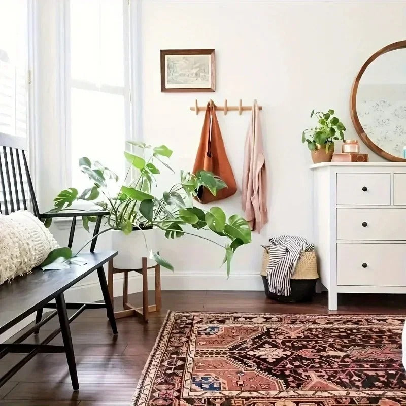 Stord peg rack above a bench in a bright entryway holding bags and a towel