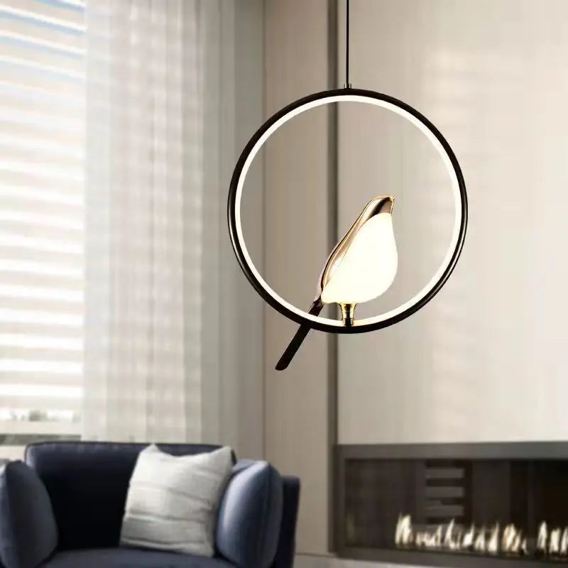 Black ring bird pendant glowing in a living room beside a navy armchair