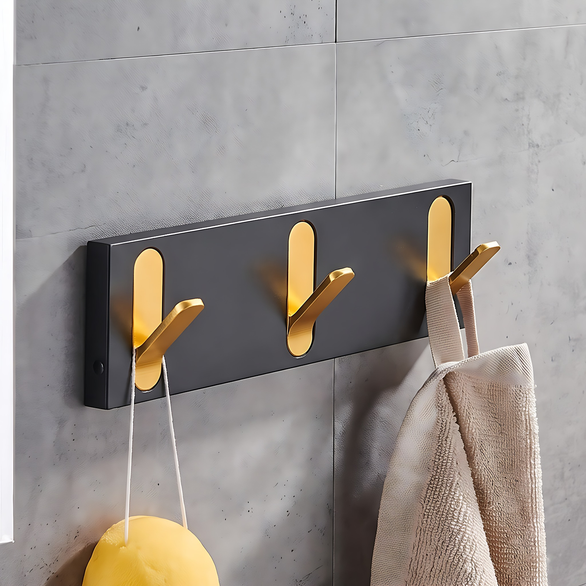 Wall hook rack with gold hooks, 3 hooks, 9.4", on a warm plaster wall