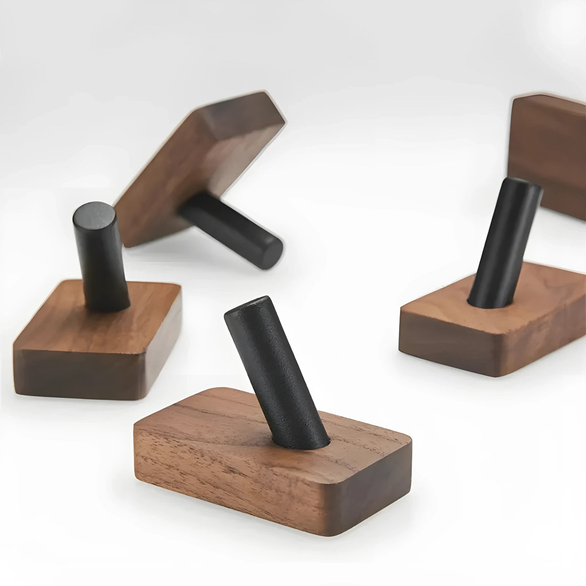 Walnut Peg hook on a table, showing its base and black peg from the side