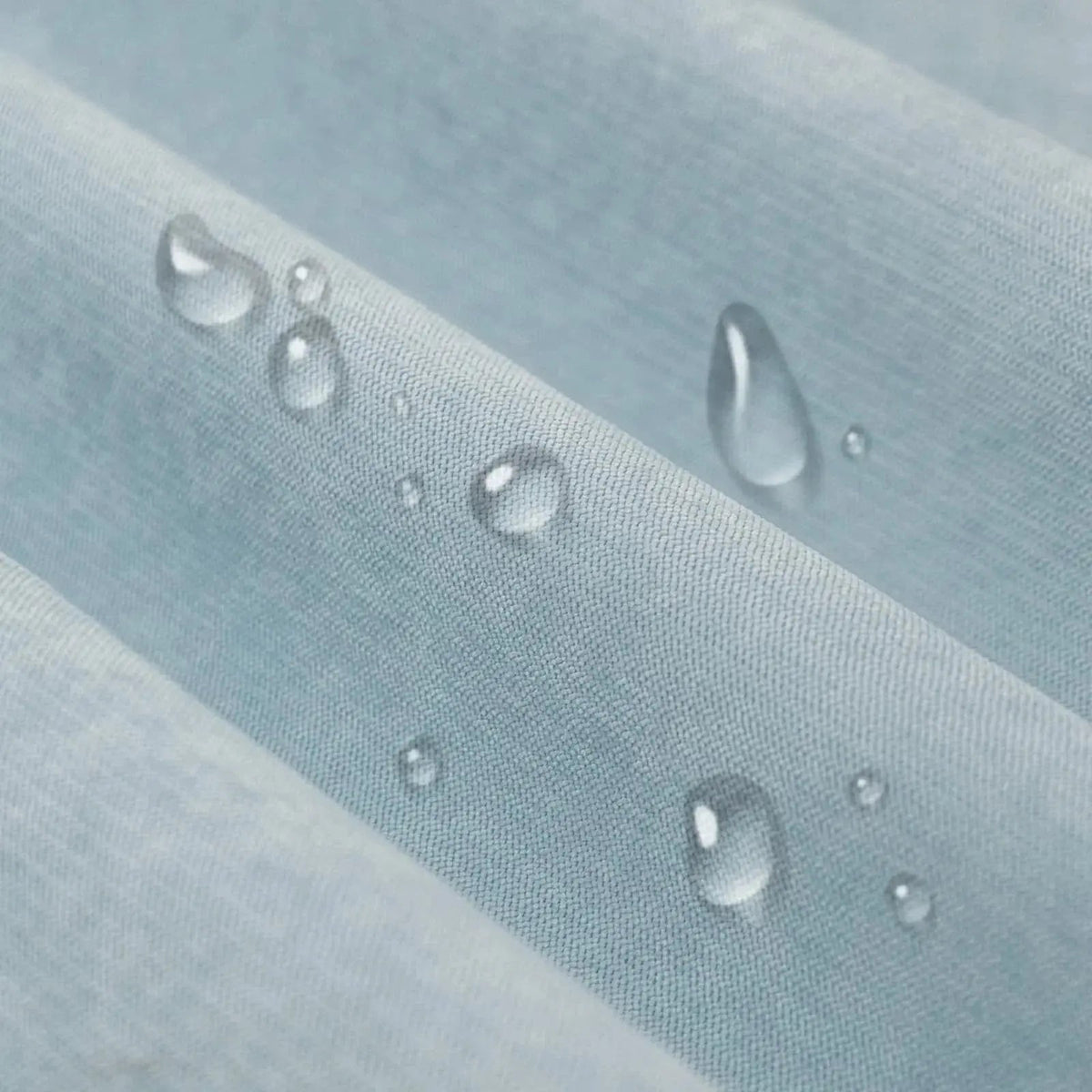 Water drops beading on the light blue sofa cover fabric