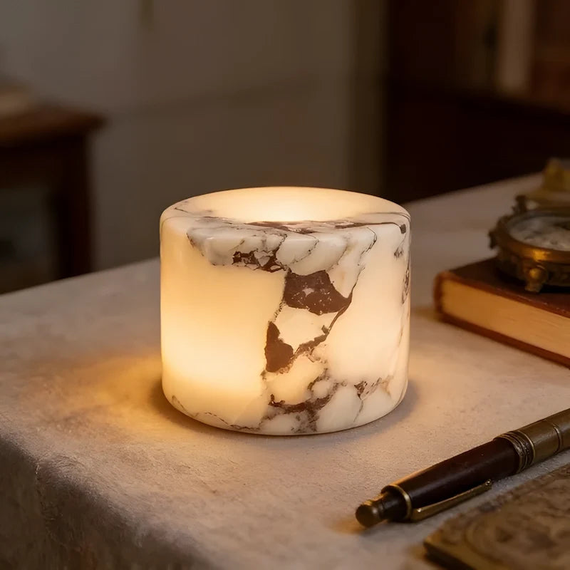Close view of the Ystad lamp in Ivory Noir marble, lit