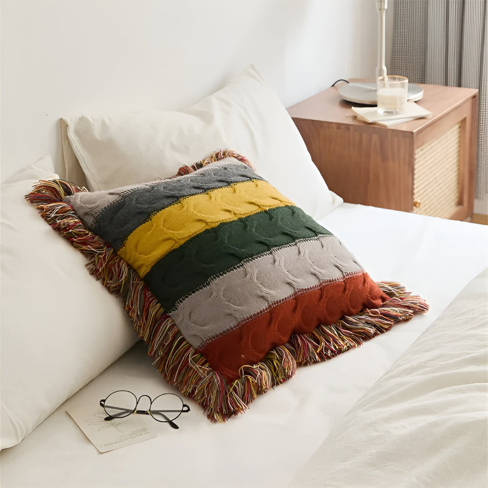 Striped cable knit cushion on a bed