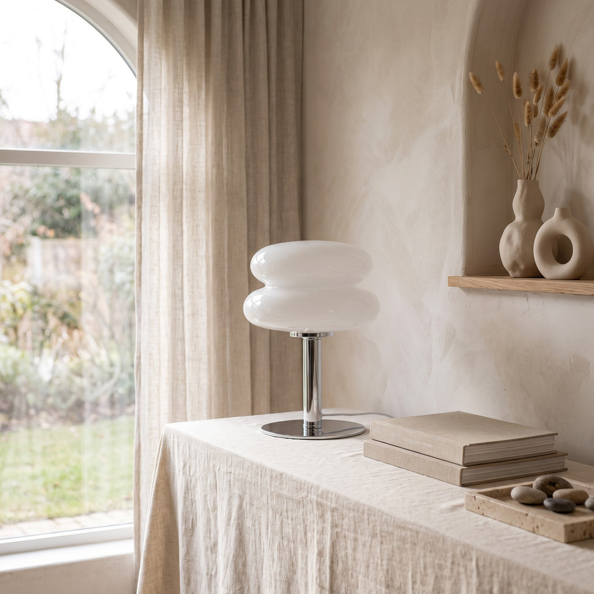 Annika glass table lamp in white on a linen covered table by a window