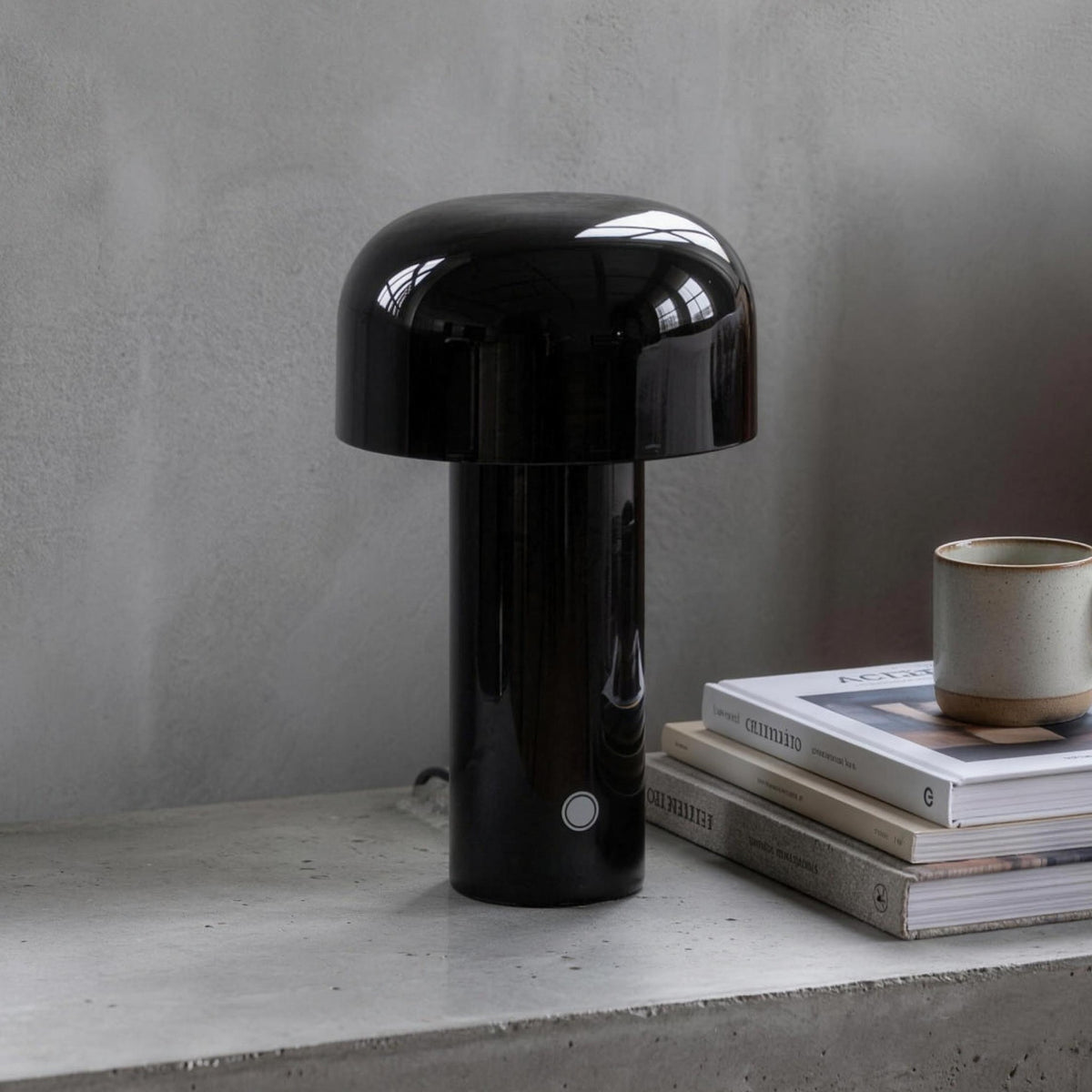 Britta dome table lamp in black on a concrete nightstand