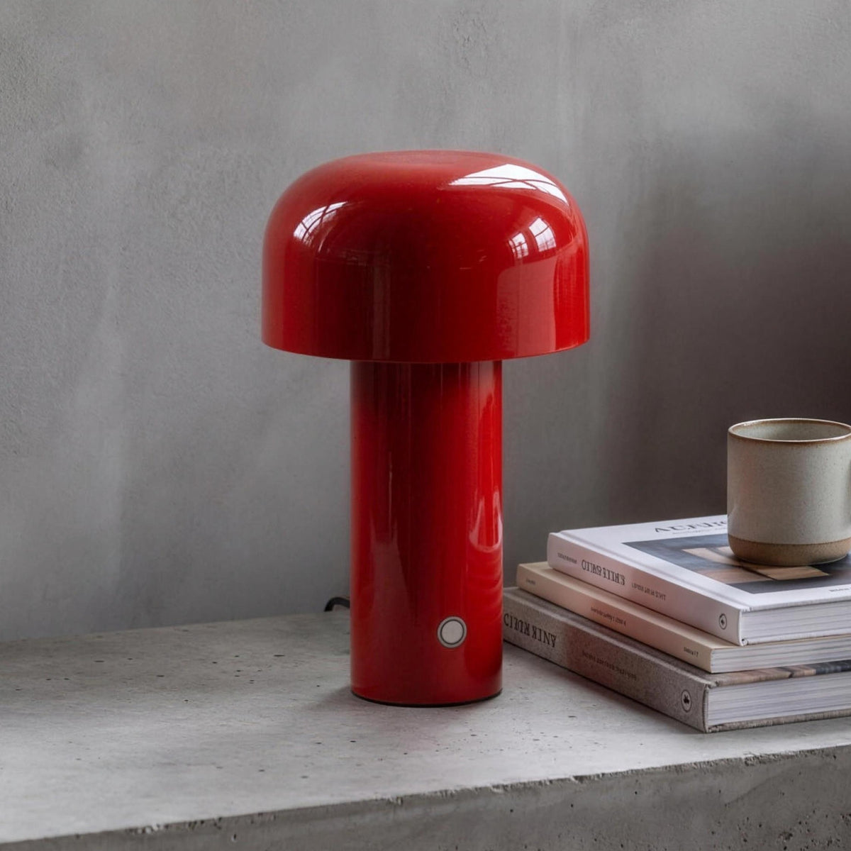 Britta dome table lamp in red on a concrete nightstand