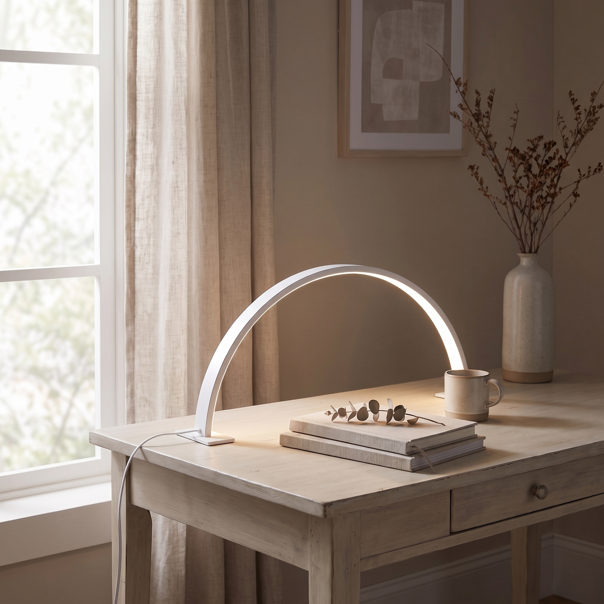 Side view of the white arc lamp showing its slim profile, flat foot and cord on a pale wood desk