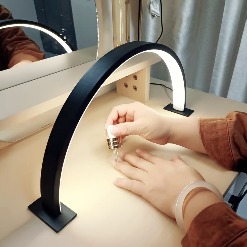 Black arc desk lamp lighting a manicure on a wooden table
