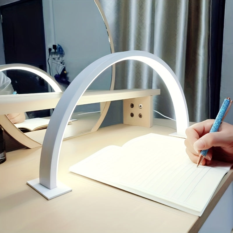 White arc desk lamp lighting a notebook on a wooden desk