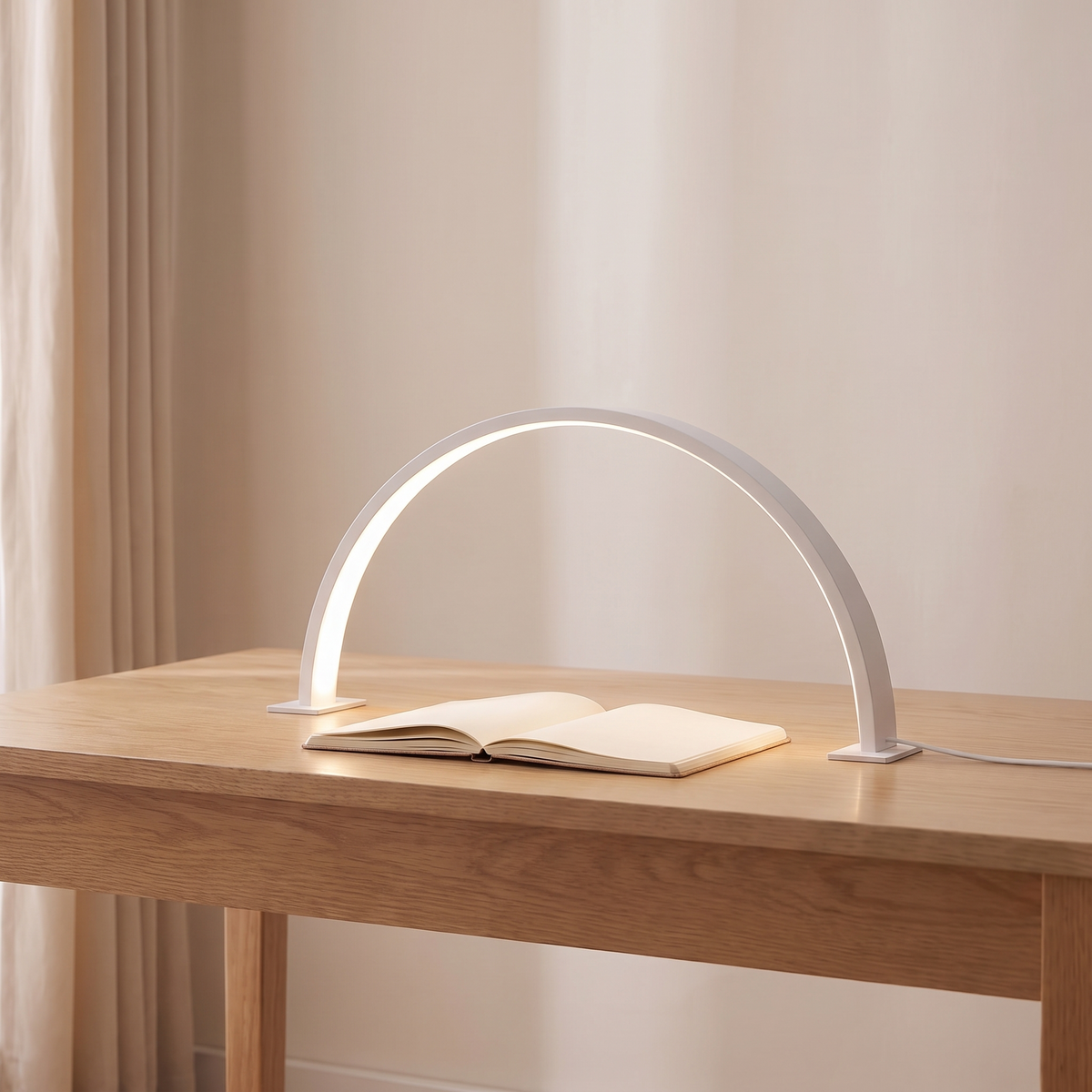 Bryn half moon desk lamp in white lit on a light oak desk