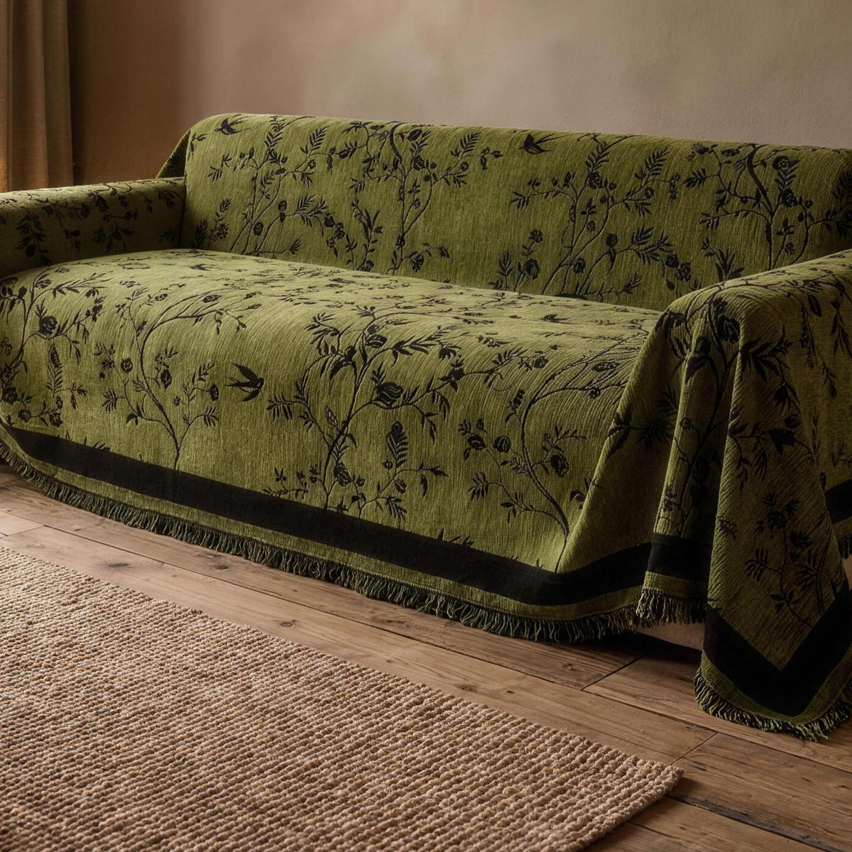 Olive green floral chenille sofa cover draped over the seat and back of a sofa in a living room