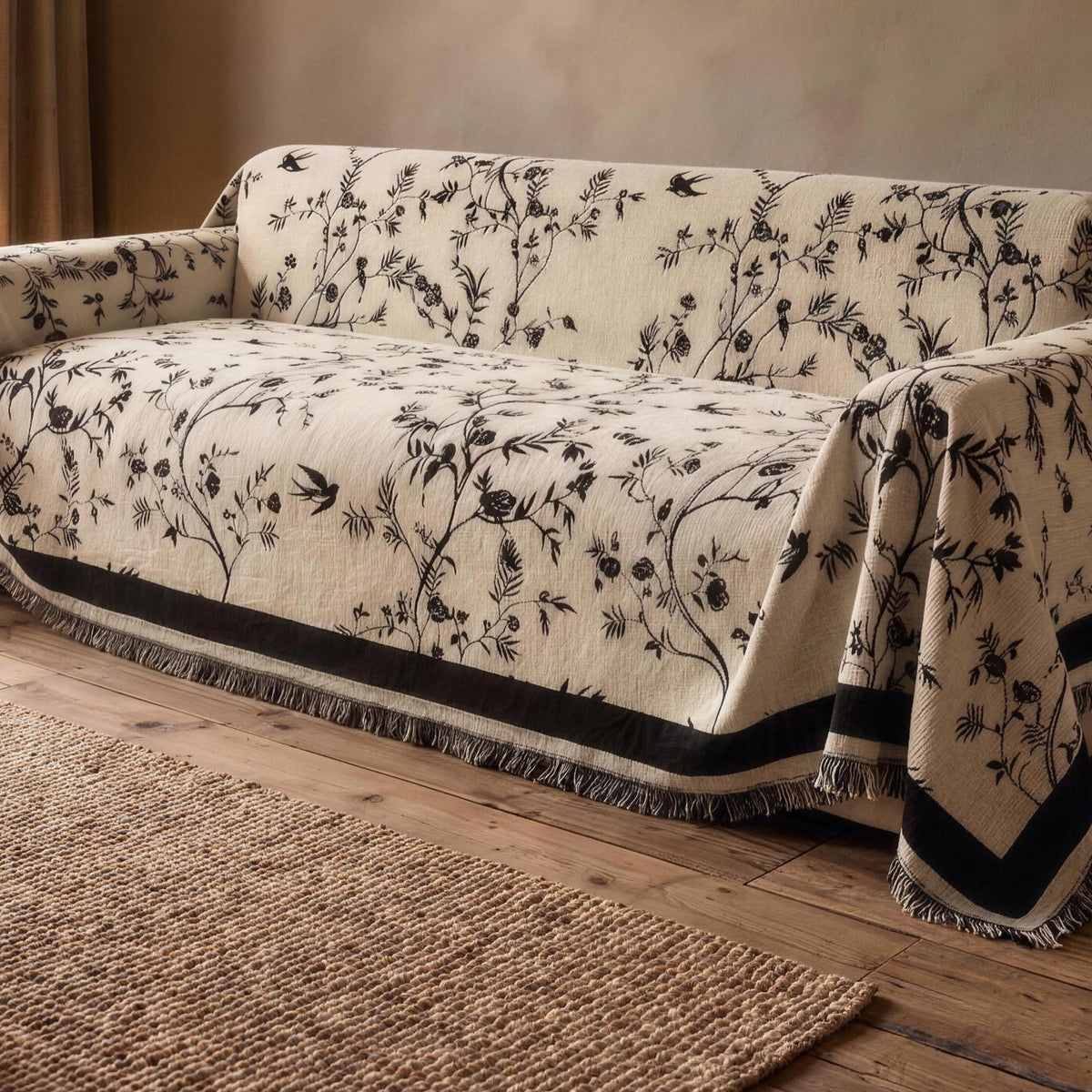 Chenille sofa cover in Cream with a black floral jacquard on a sofa