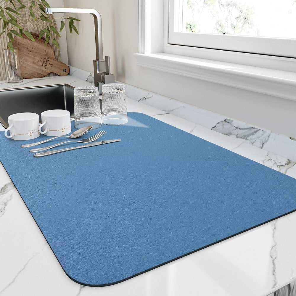 Blue dish drying mat with cups by a sink
