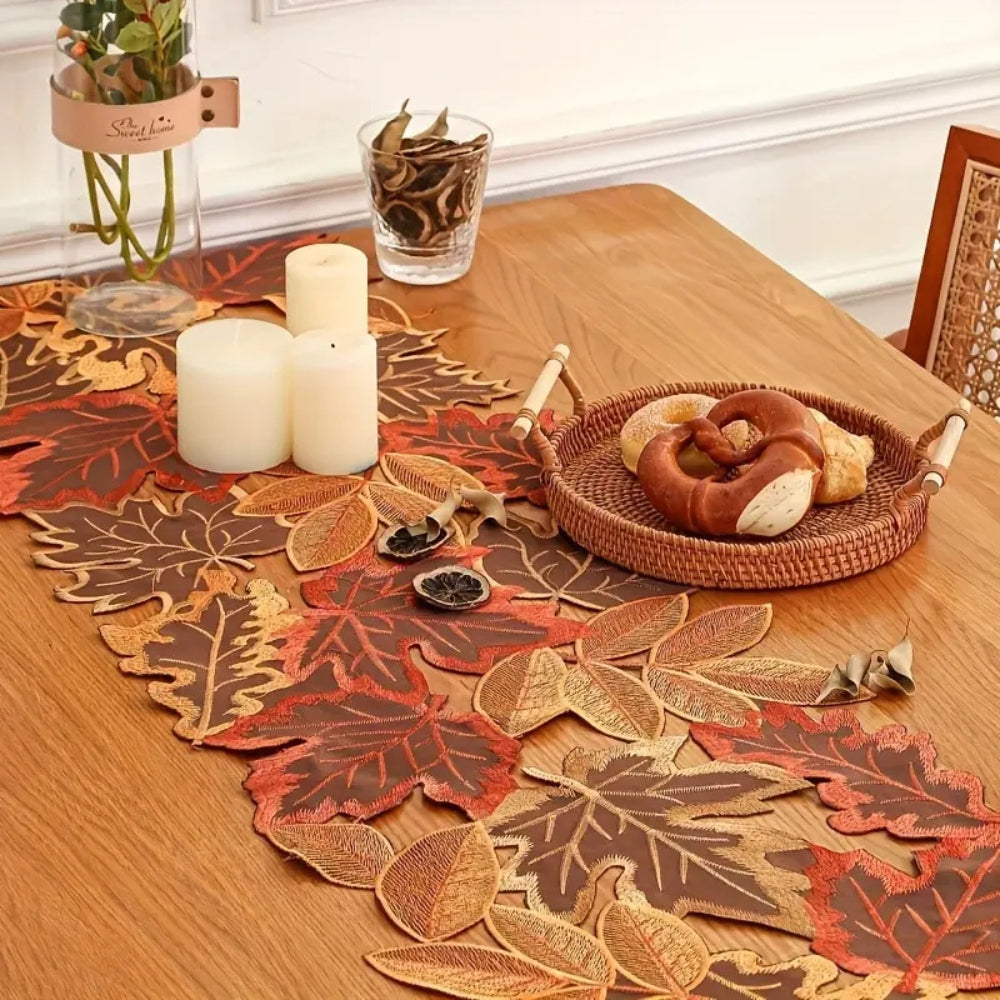 Embroidered leaf runner with pillar candles on an oak table