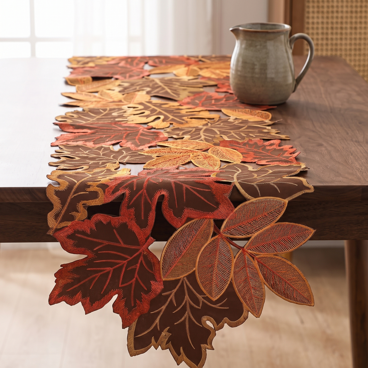 Embroidered maple leaf table runner with a cutwork edge on a dark walnut dining table