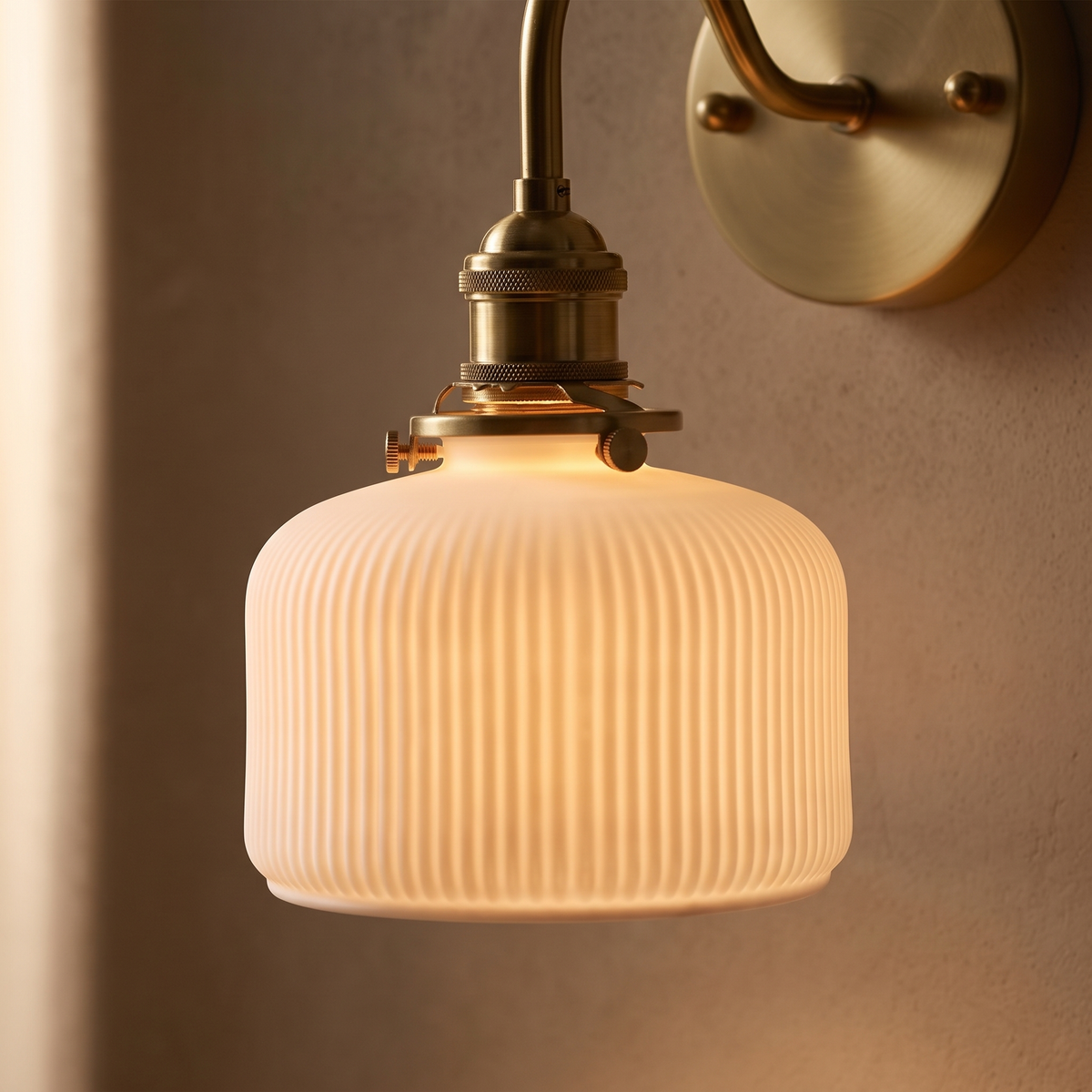 Close view of the ribbed ceramic shade glowing below the brass socket