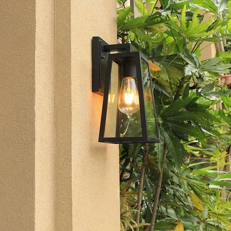 Fjell lantern on a wall beside garden plants