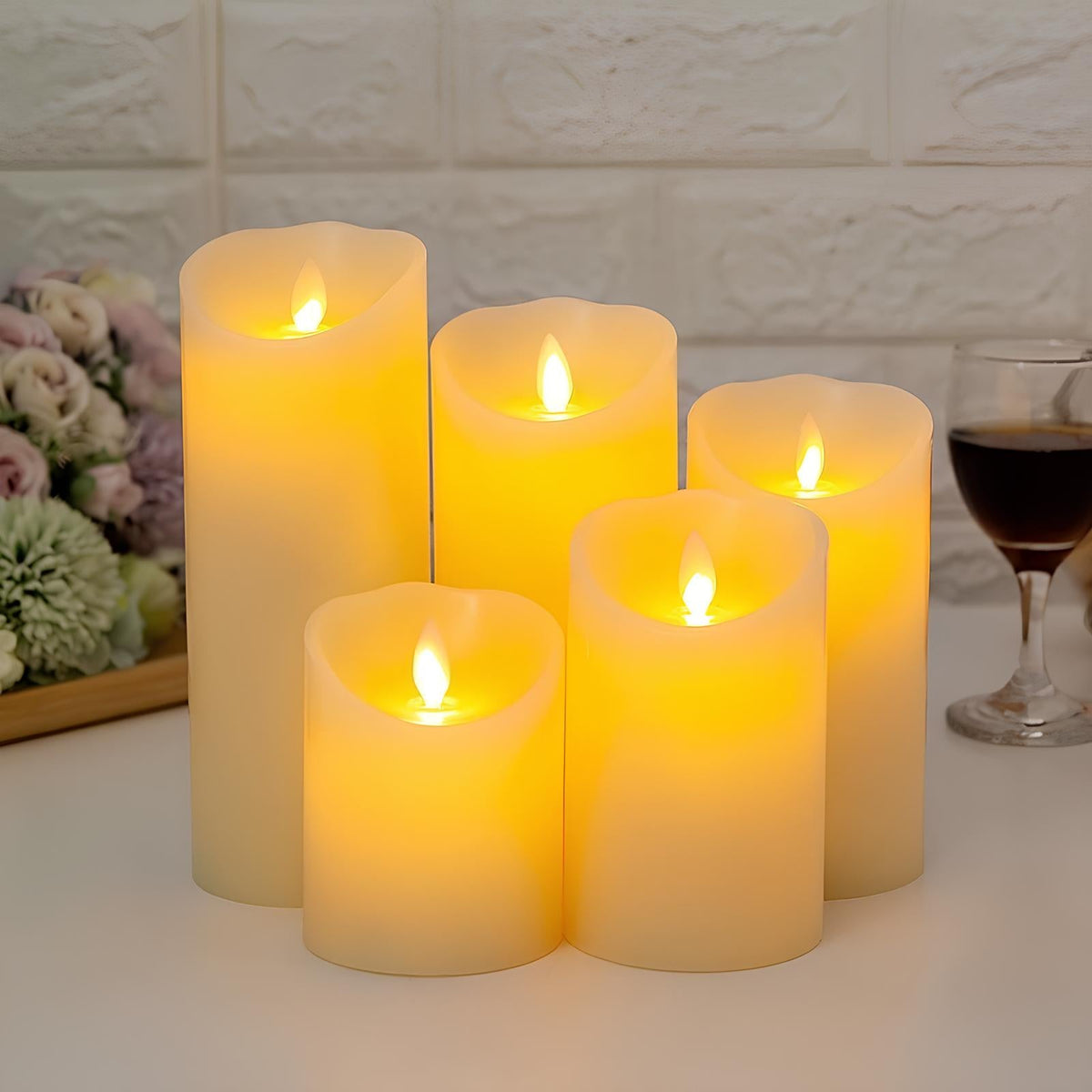 Classic flameless pillar candles beside a wine glass