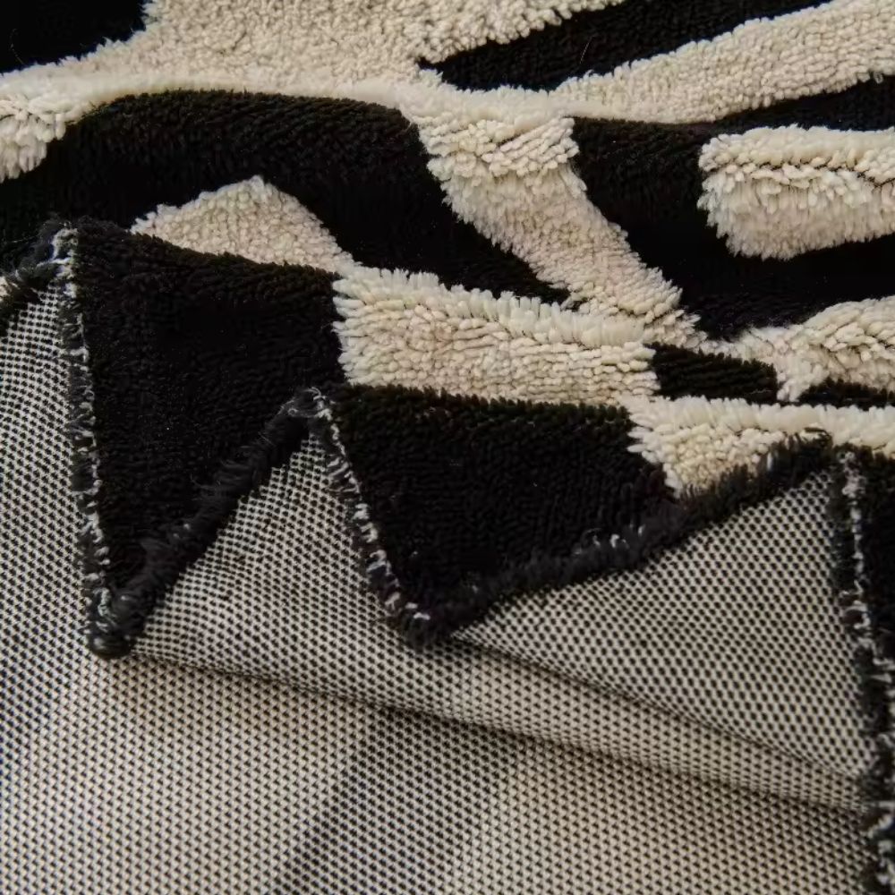 Corner of the geometric jacquard cover folded back to show the woven back and pile