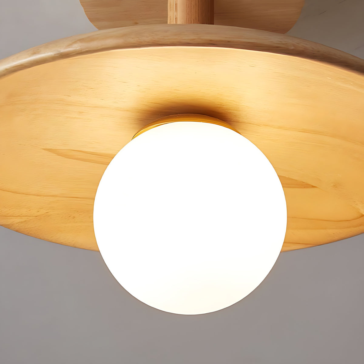 The frosted glass globe under the wood disc of the Gerda semi flush ceiling light