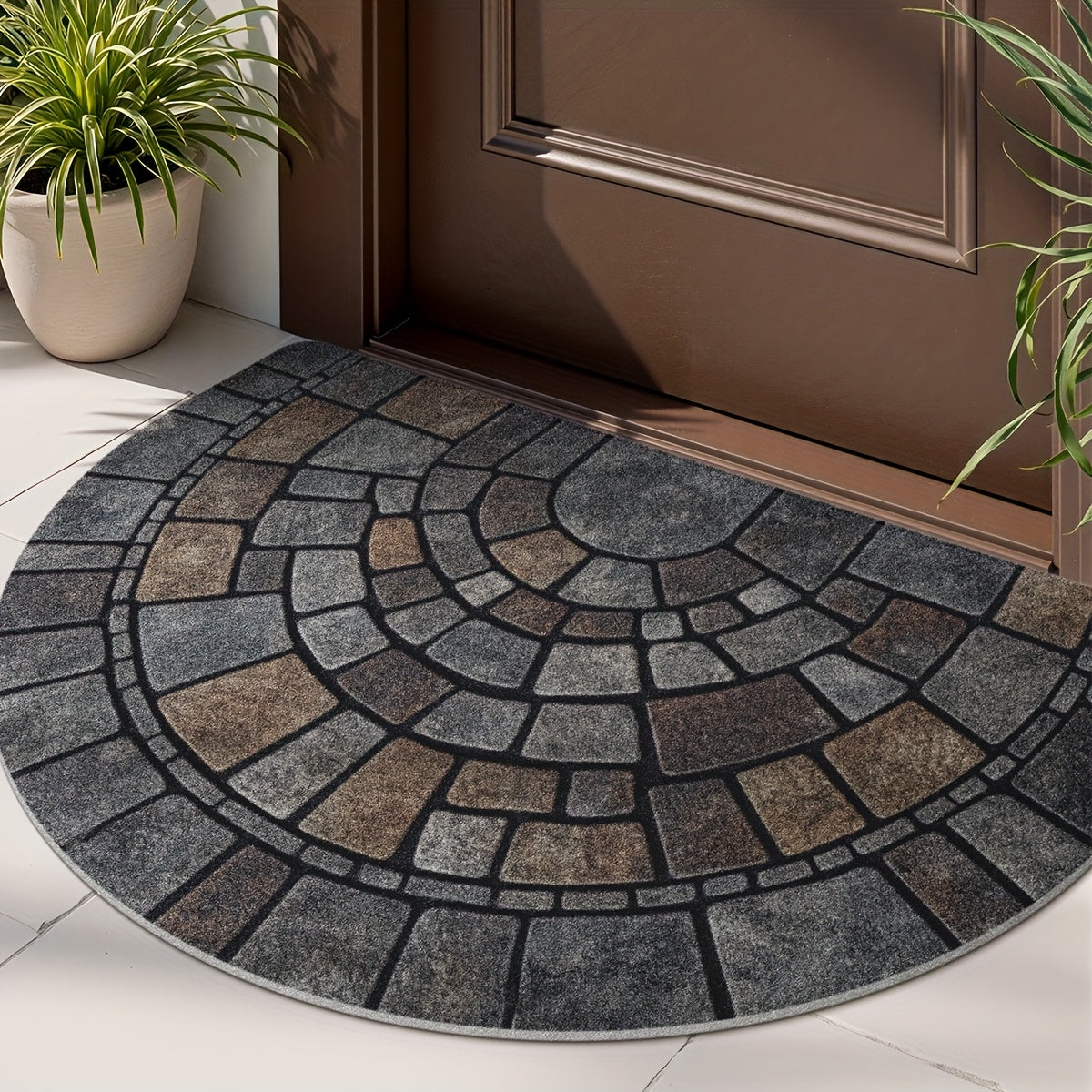 Half round mosaic door mat at a wood front door beside a potted plant