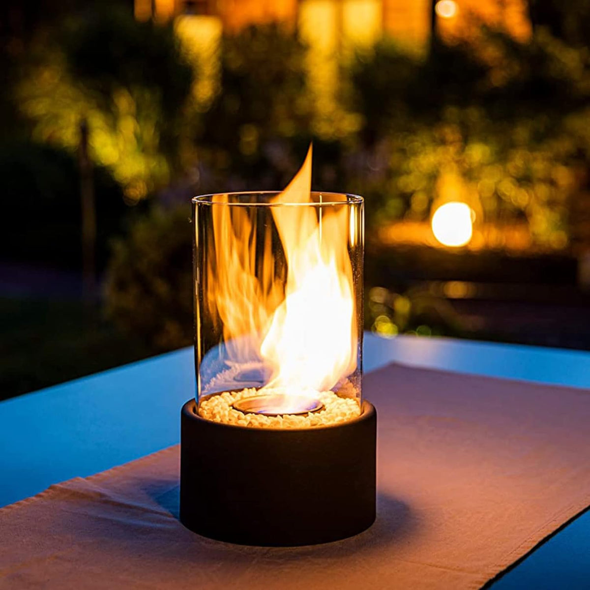 Horten fire lamp lit on an outdoor table at night