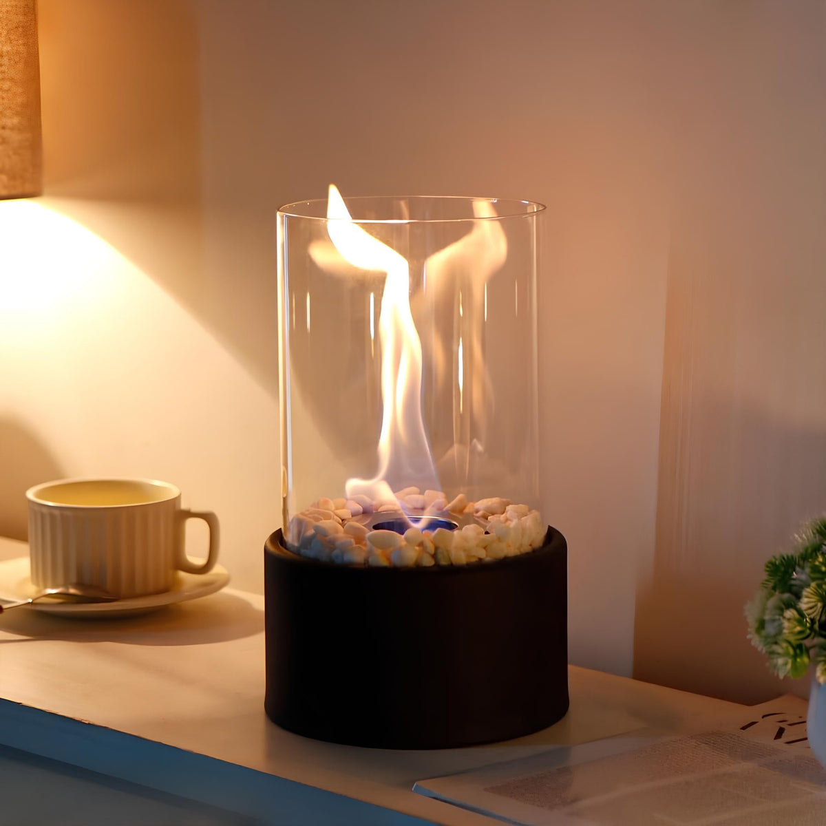 Horten fire lamp in black lit beside a coffee cup