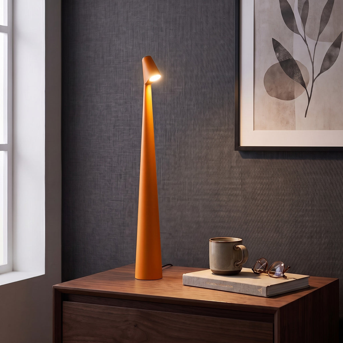 Iben table lamp in Orange on a nightstand beside a window