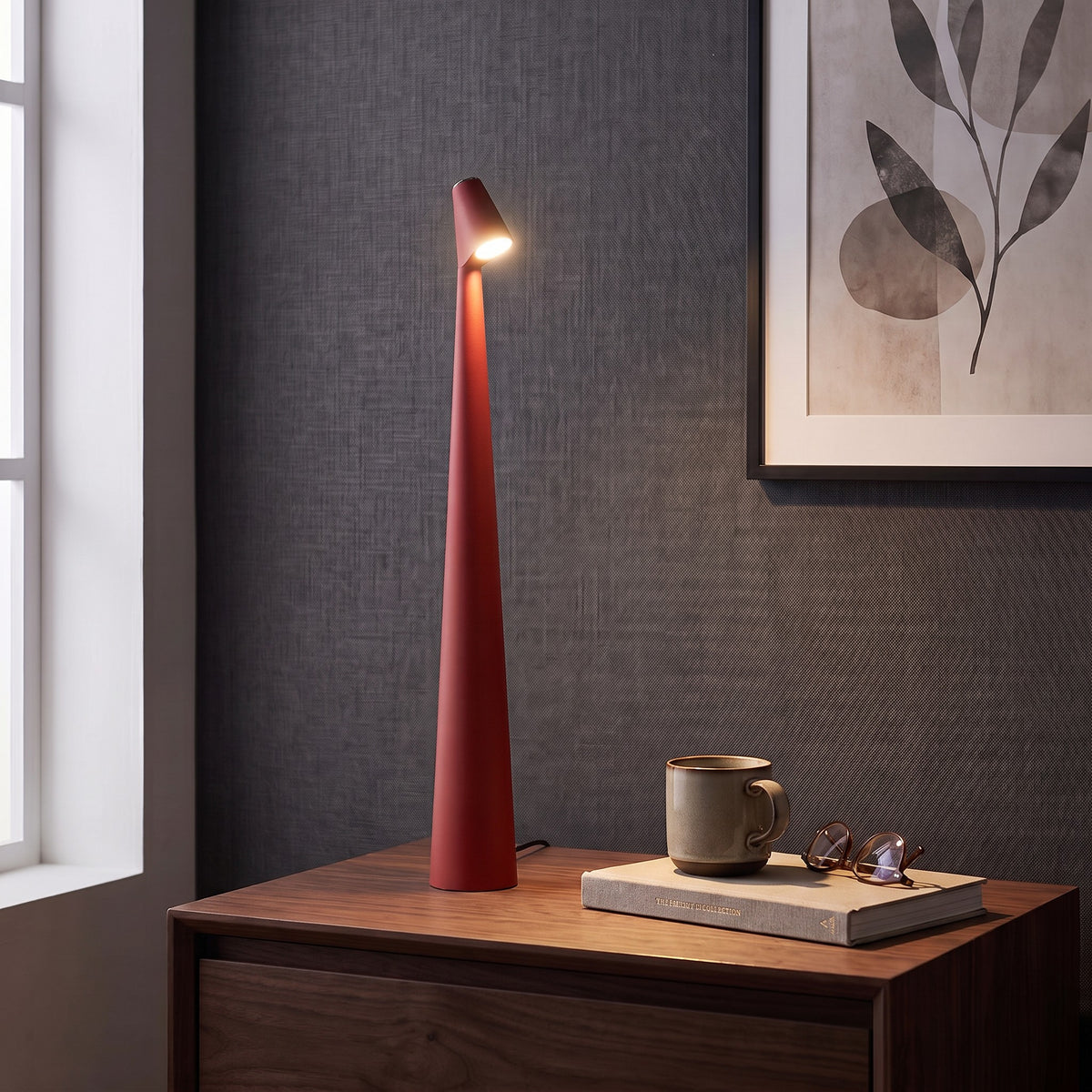 Iben table lamp in Red on a nightstand beside a window