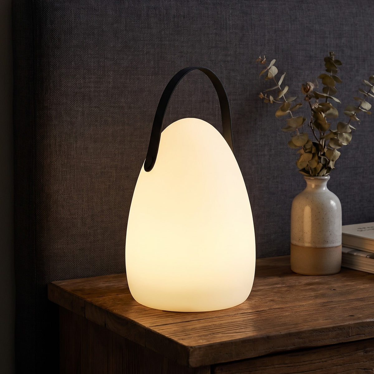 Teardrop Kari cordless lamp glowing on a nightstand