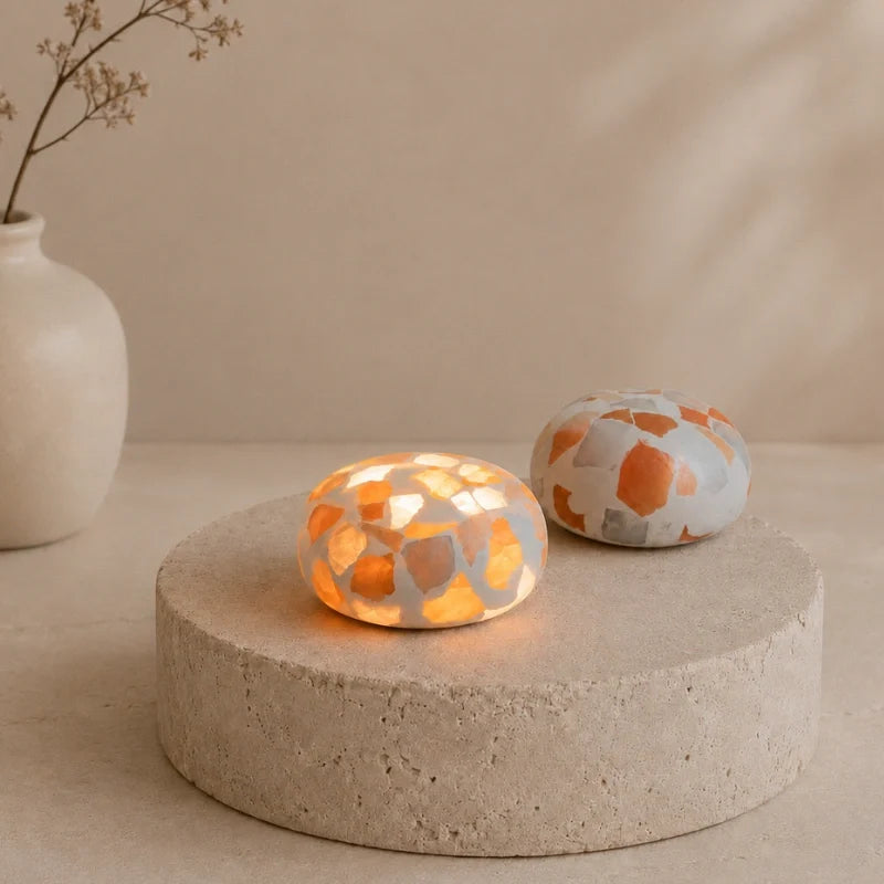 Two Kvist dome lights in Terrazzo on a stone plinth