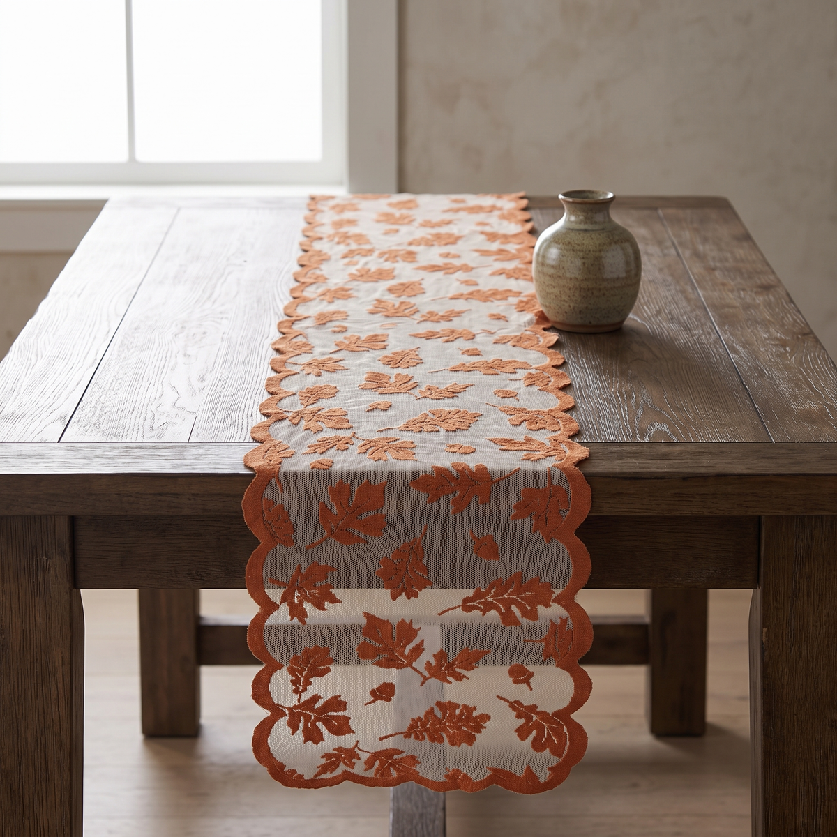 Rust leaf lace table runner with scalloped edges on a dark oak dining table