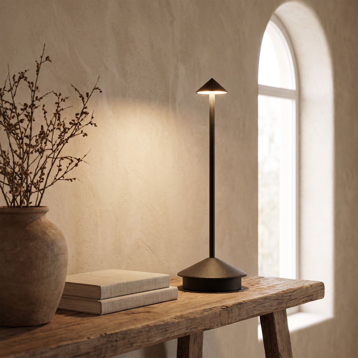 Black Lene cordless table lamp lit on a rustic wooden bench