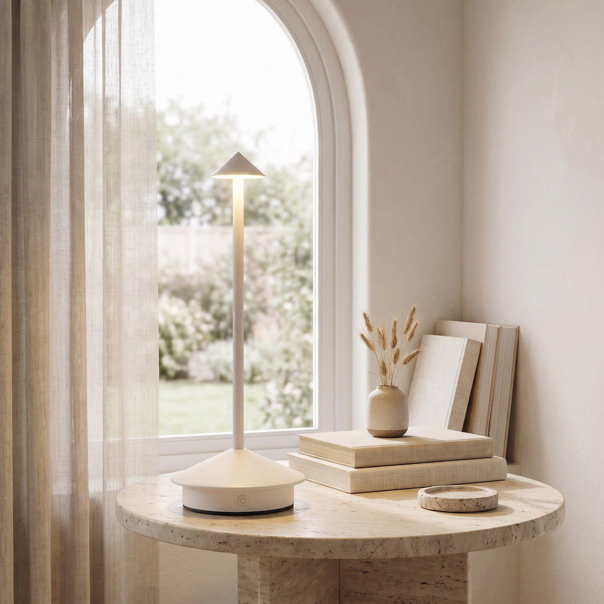 White Lene cordless table lamp on a stone side table by a window