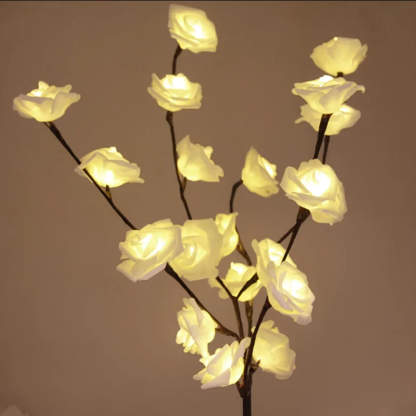 Lighted branches with white roses glowing