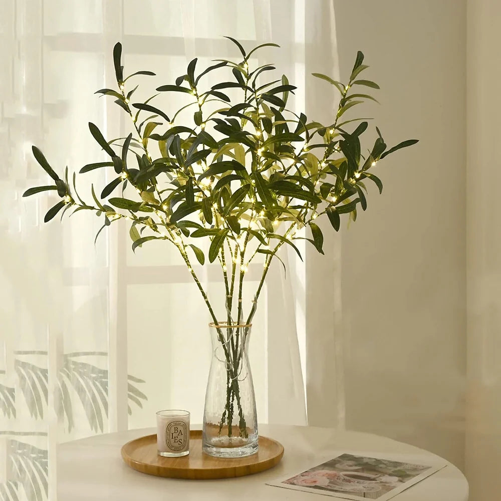 Lighted olive branches in a clear glass vase