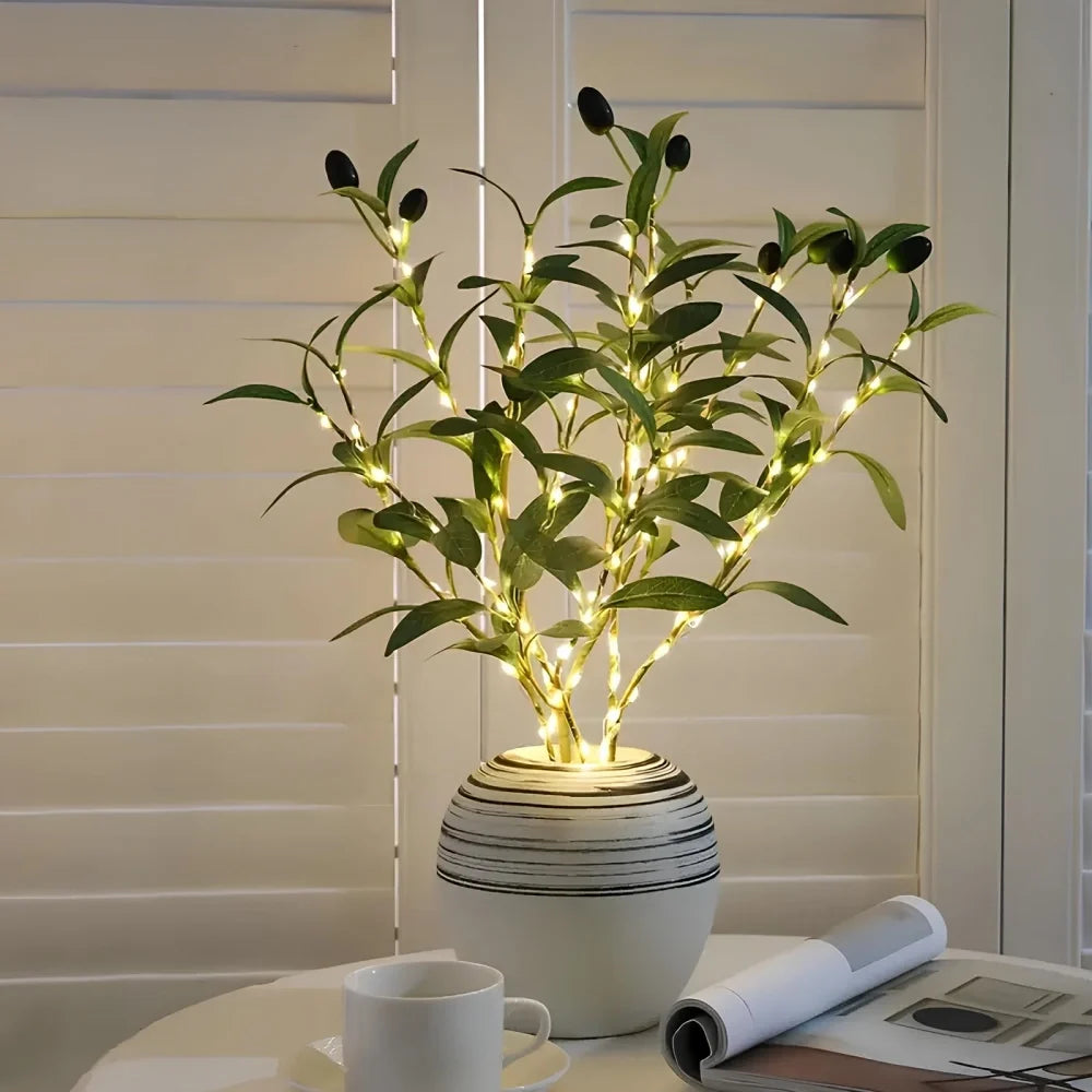 Lighted olive branches in a vase on a side table