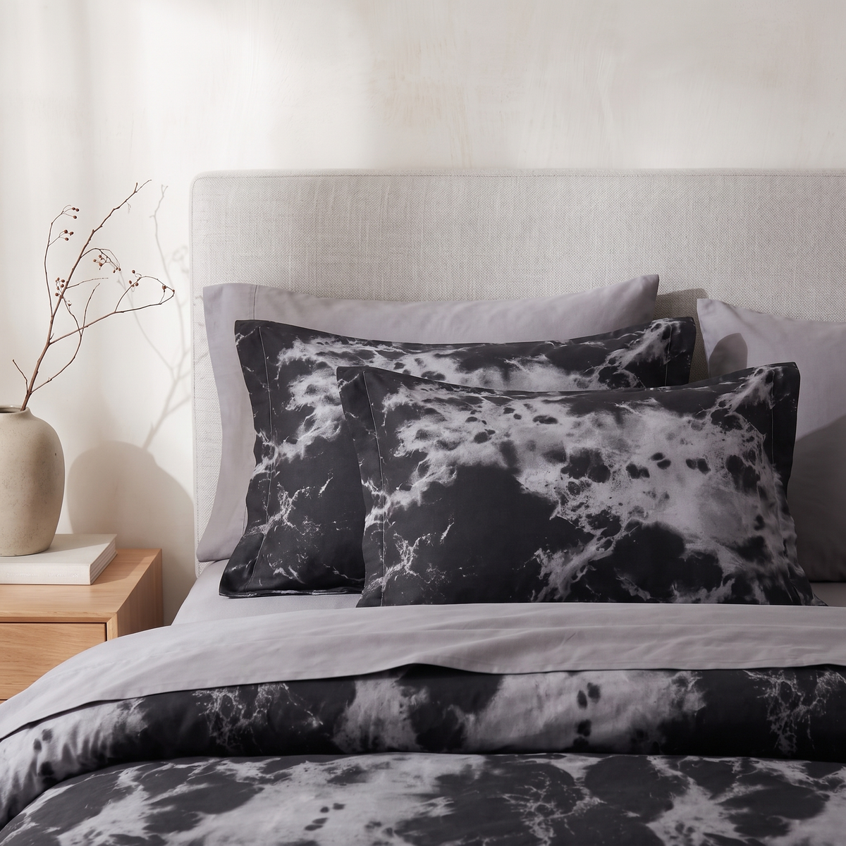 Two black marble pillowcases against a headboard