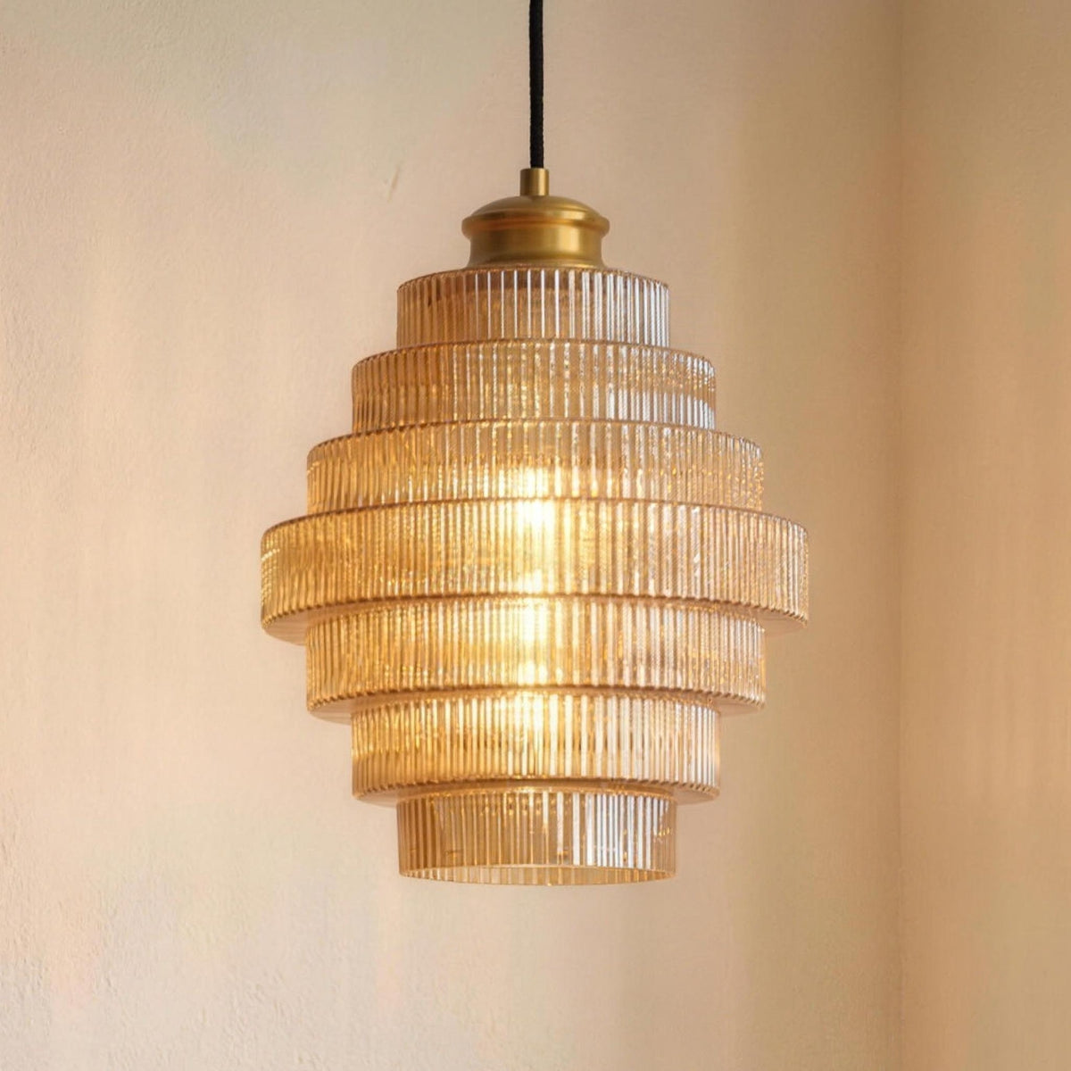 Minna pendant light in Amber hanging low over a round table set with two coffee cups