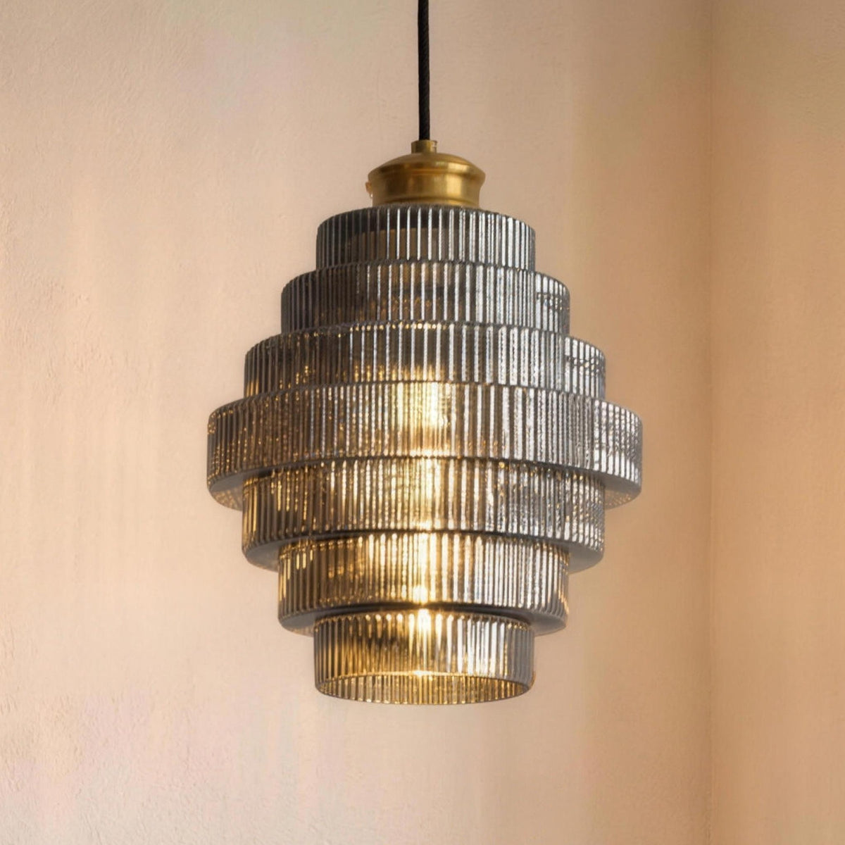 Minna pendant light in Smoke Gray hanging low over a round table set with two coffee cups