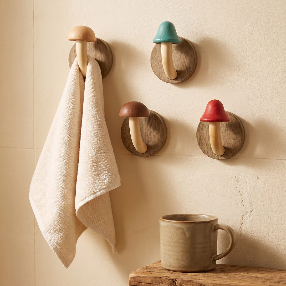 Mushroom wall hook holding a hand towel on a bathroom wall