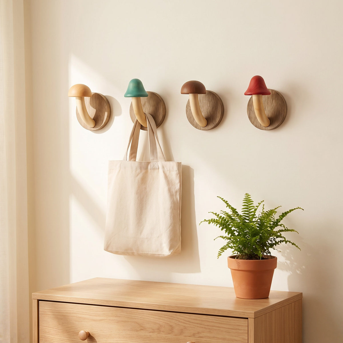 Mushroom wall hooks above a nursery dresser, one holding a canvas tote