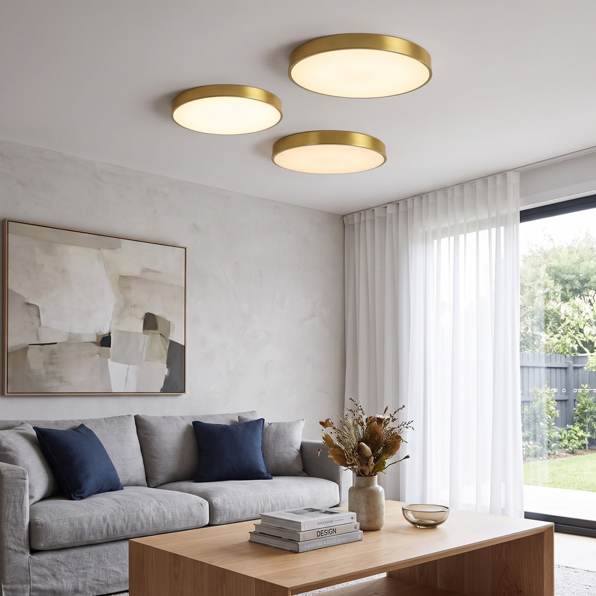 Three gold Nelli LED ceiling lights over a living room with a gray sofa
