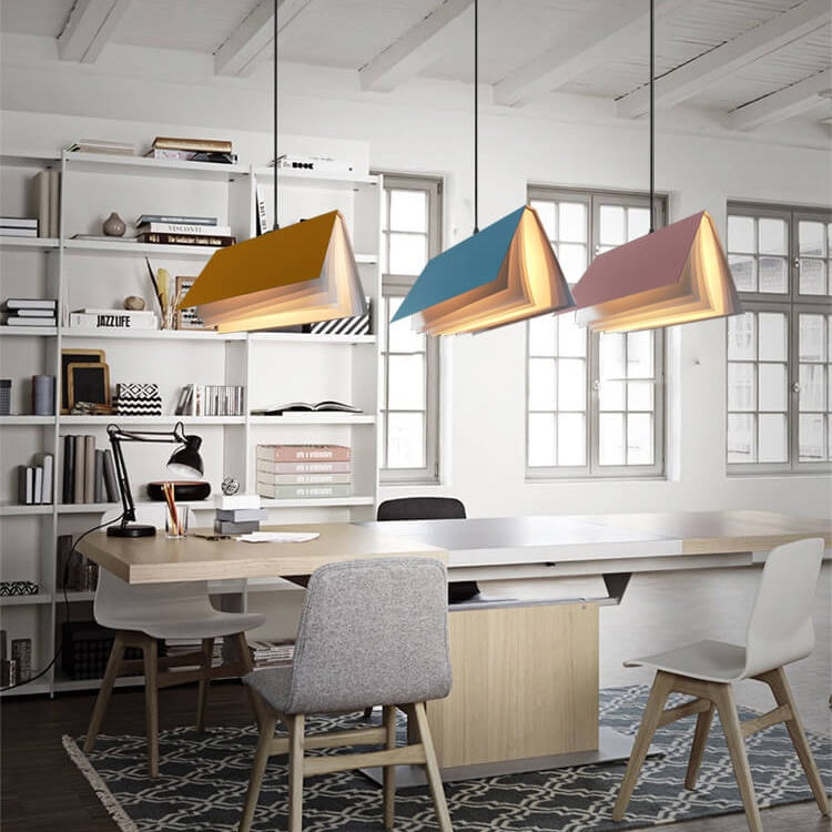 Yellow, blue and pink book pendants hung over a long desk in a home office