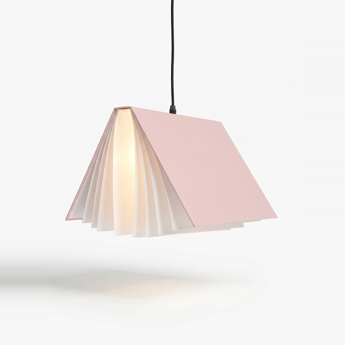 Pink book pendant light lit on a white background