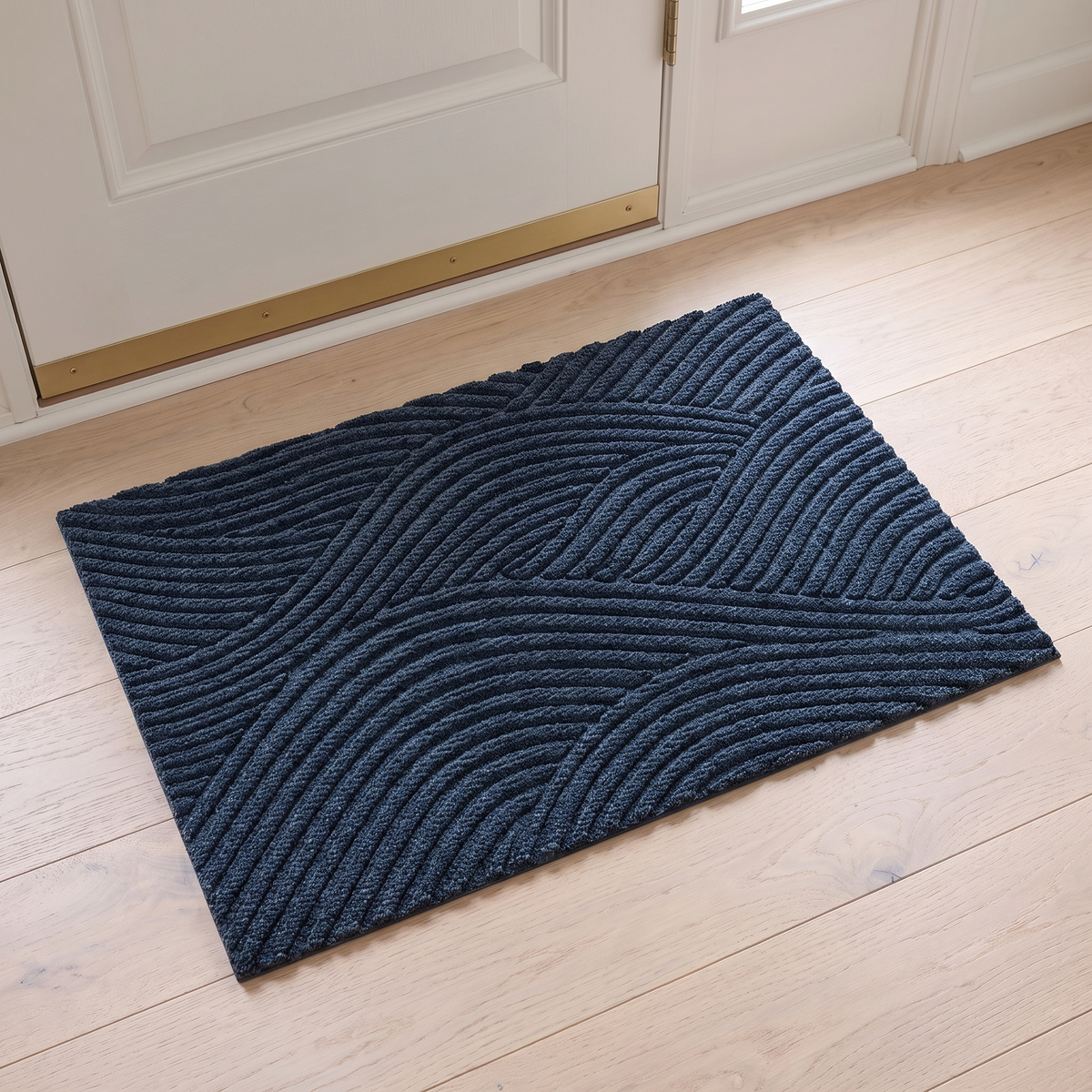 Non slip door mat in blue inside a white front door